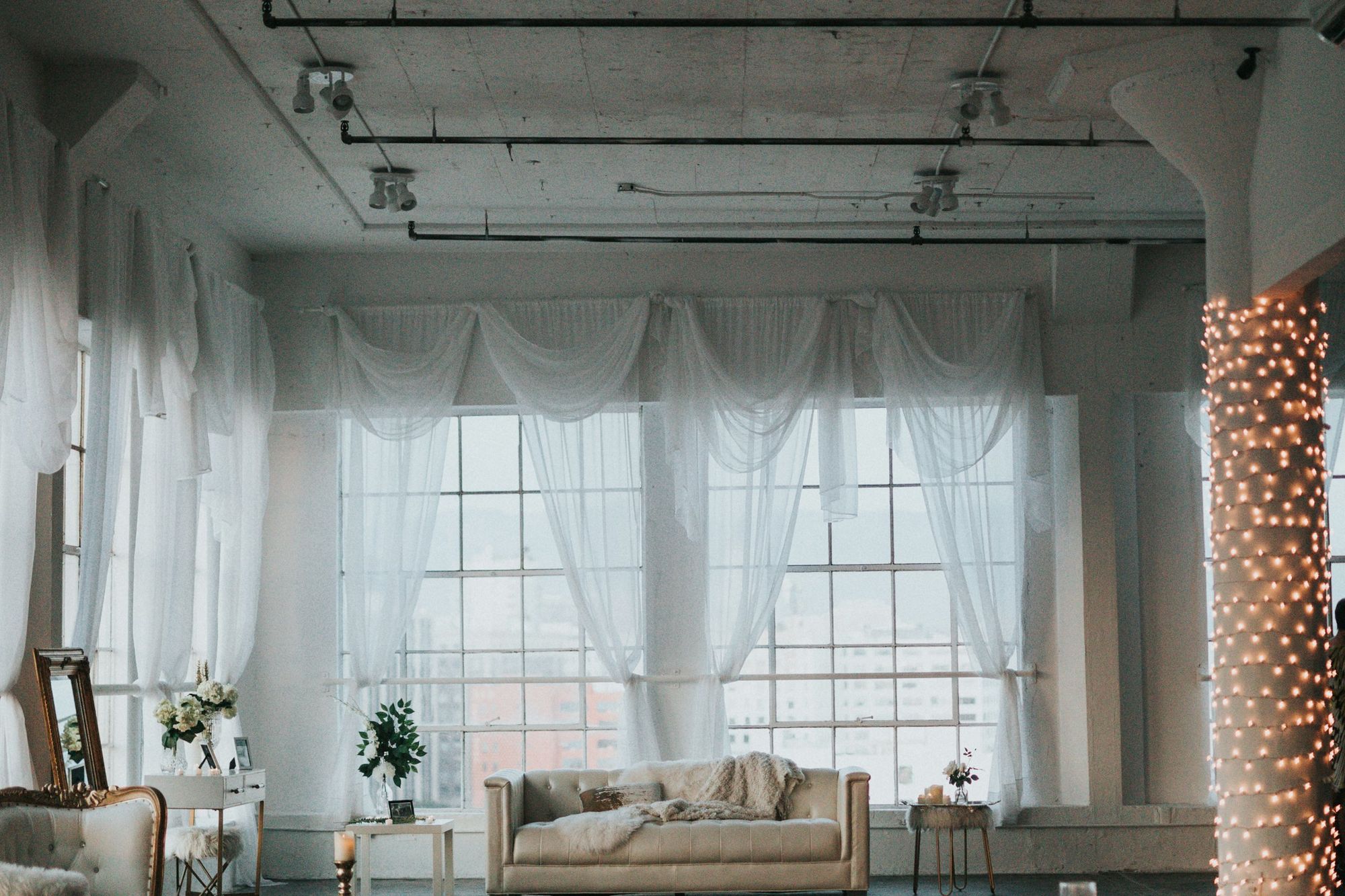 The Loft: tall windows hung with sheer curtains above a cream sofa